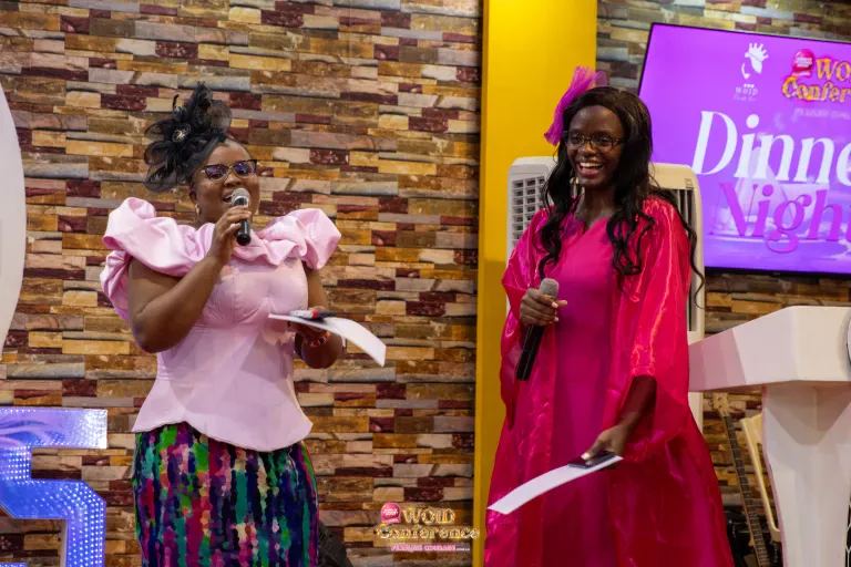 Two women in pink address the guests at the Dinner Night.