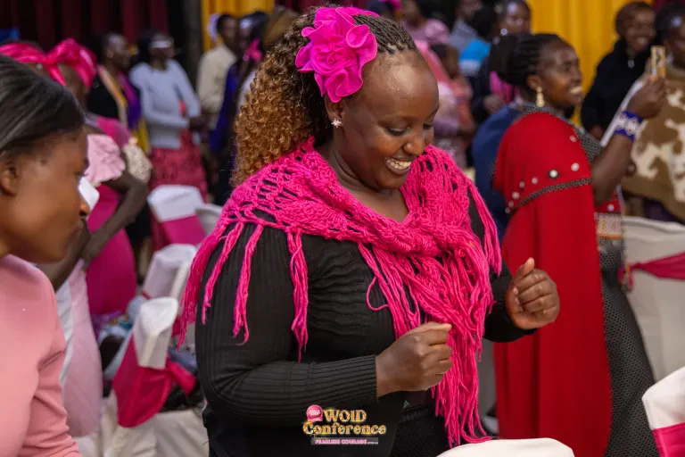 A woman with a pink flower in her hair smiles at the Dinner Night.