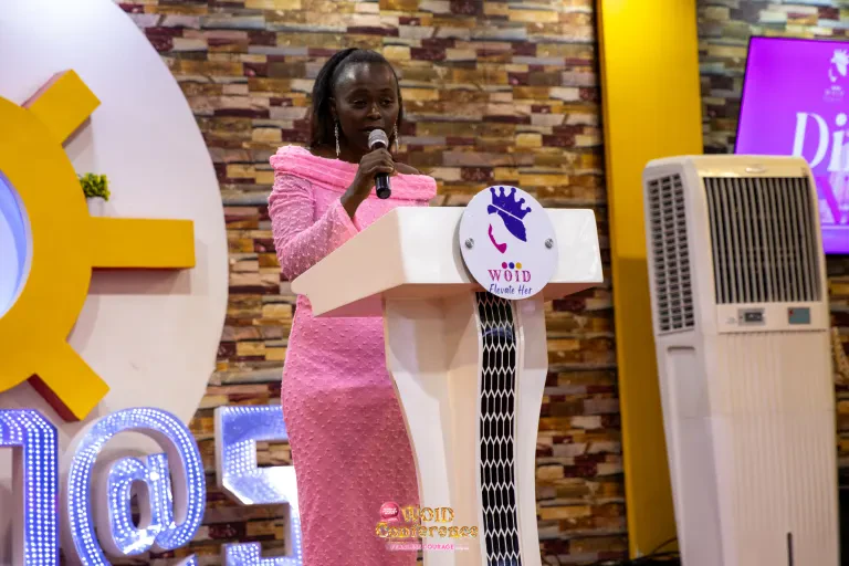 A woman in pink speaks at the WOID lectern.
